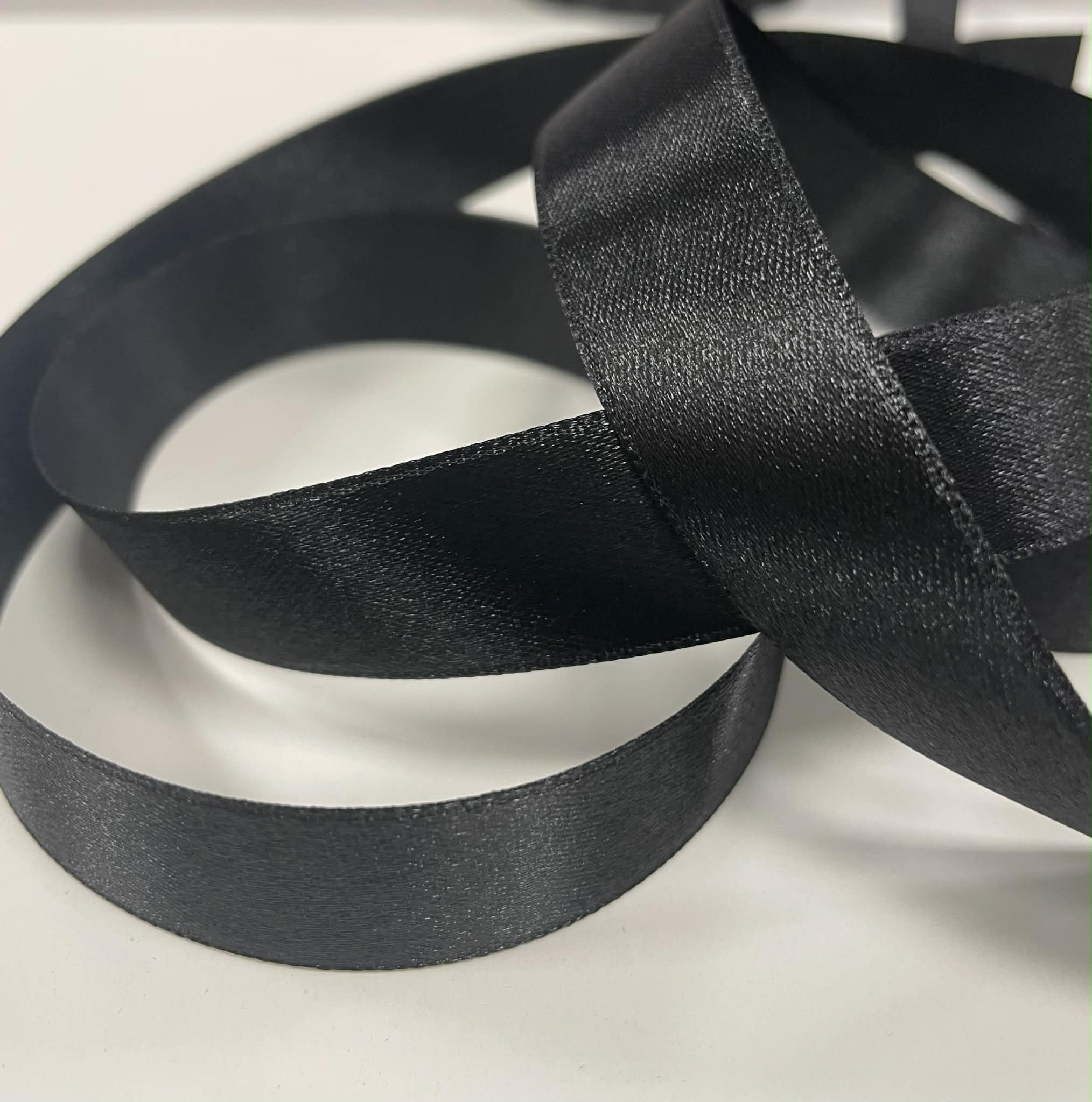 Atlasinė juostelė 20mm, juoda Atlasinė juostelė 20mm, juoda (minkštesnė) — siuvimo juostelė | Trys Pelėdos